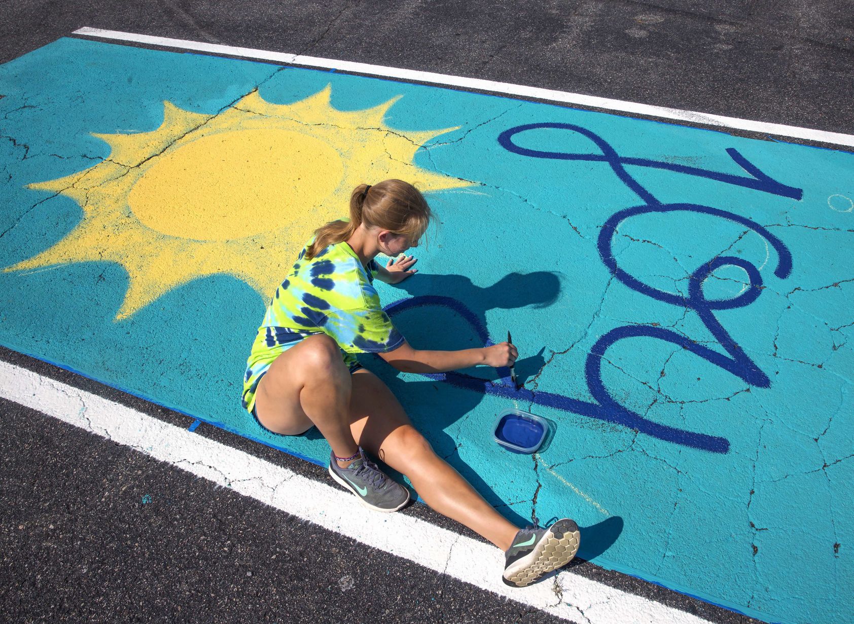 Students painting their parking spaces